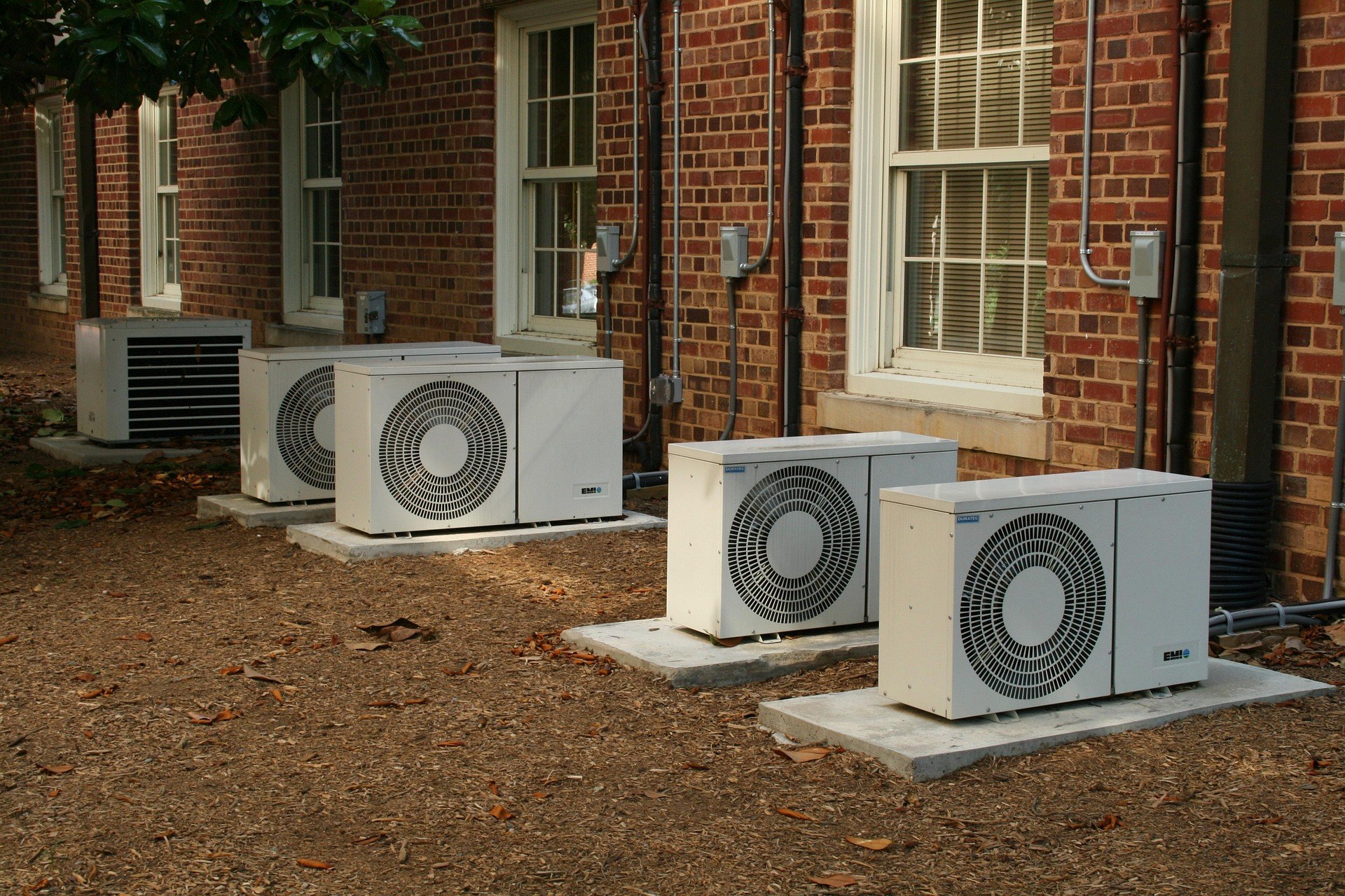 Multiple outdoor air-conditioning units outside a brick building
