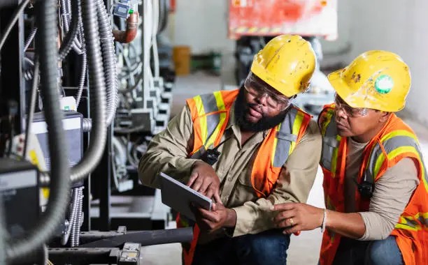 Engineers reviewing commercial HVAC equipment on site