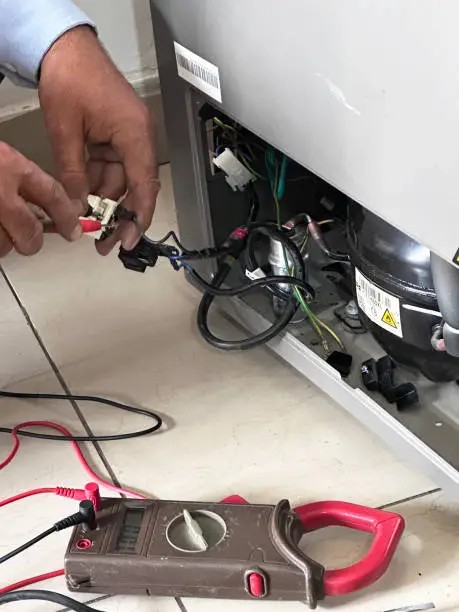 Technician repairing a refrigeration compressor and wiring