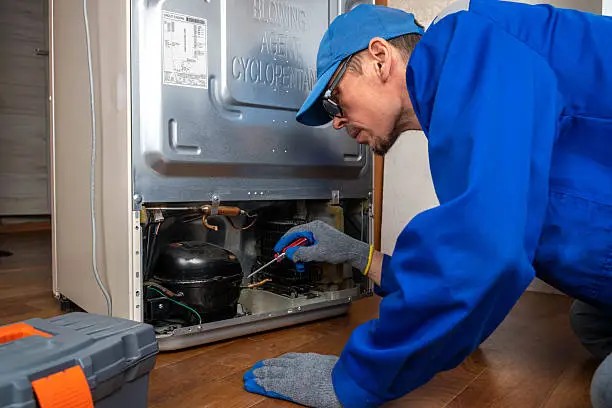 Technician servicing a refrigeration unit