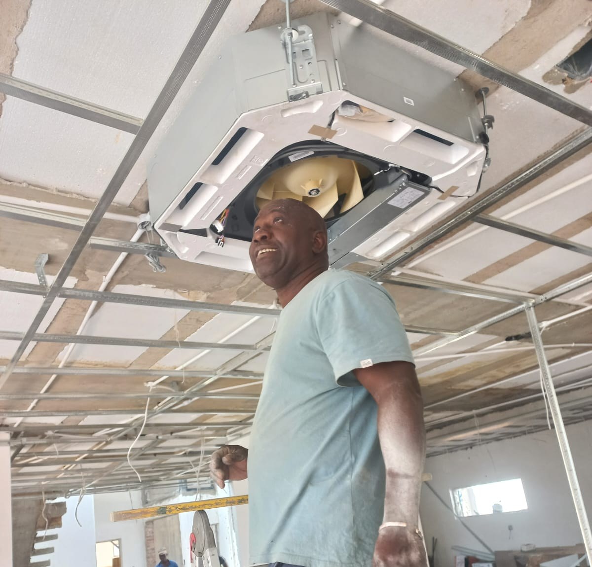 Easy Air technician inspecting a ceiling cassette air-conditioning unit