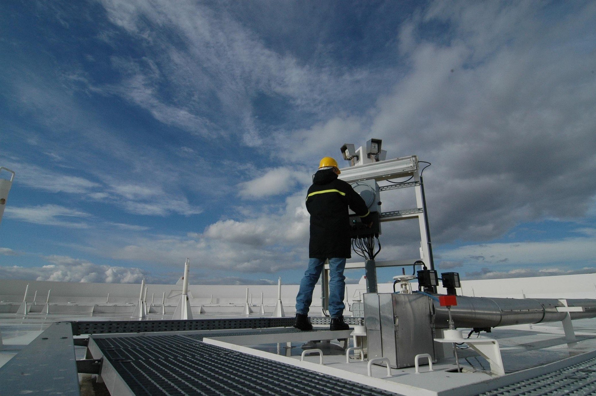 Technician working on rooftop cooling equipment